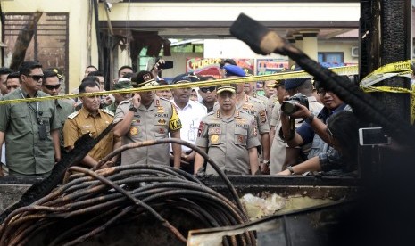 Kapolri Jendral Pol Tito Karnavian (kanan) didampingi Kapolda Lampung Irjen Pol Purwadi Arianto (ketiga kiri) meninjau Kantor Mapolres Lampung Selatan yang terbakar di Lampung Selatan, Lampung, Senin (6/5/2019). 