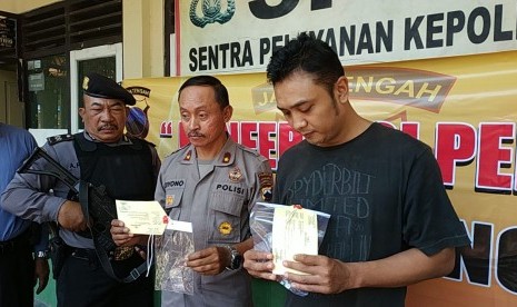 Kapolsek Serengan Polresta Solo, Kompol Giyono (tengah), bersama tersangka Deni Hendarto (kaus hitam) memperlihatkan barang bukti penangkapan kasus narkotika jenis shabu, di Polsek Serengan, Solo, Selasa (16/7). 