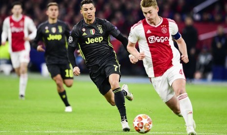 Kapten Ajax Matthijs De Ligt (kanan) menggiring bola dikejar striker Juventus Cristiano Ronaldo.