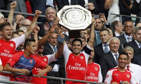 Kapten Arsenal, Mikel Arteta (tengah) mengangkat trofi Community Shield.