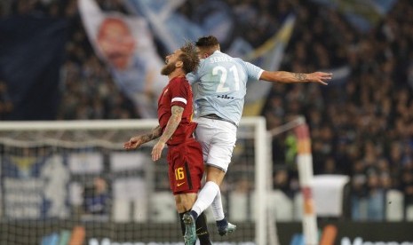 Kapten AS Roma, Danielle De Rossi berebut bola di udara dengan gelandang Lazio, Sergej Milinkovic-Savic pada laga Serie A di Olimpico, Ahad (19/11) dini hari WIB. Roma menang 2-1.