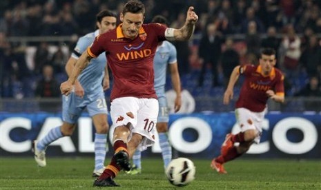 Kapten AS Roma, Francesco Totti, saat menjebol gawang Lazio lewat titik putih di laga Derby della Capitale di Stadion Olimpico, Roma, Selasa (9/4) dini hari WIB.