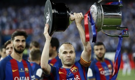 Kapten Barcelona, Andreas Iniesta mengangkat trofi Copa del Rey setelah timnya mengalahkan Deportivo Alaves, di Vicente Calderon, Ahad (28/5) dini hari WIB.