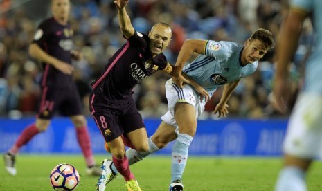 Kapten Barcelona, Andres Iniesta (kiri) berduel dengan pemain Celta Vigo, Nemanja Radoja pada laga La Liga di Estadio Balaidos, Senin (3/10) dini hari WIB. Barca kalah 3-4 pada laga ini.