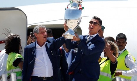 Kapten Cristiano Ronaldo dan pelatih timnas Portugal Fernando Santos memegang trofi Piala Eropa 2016 saat keluar dari pesawat.