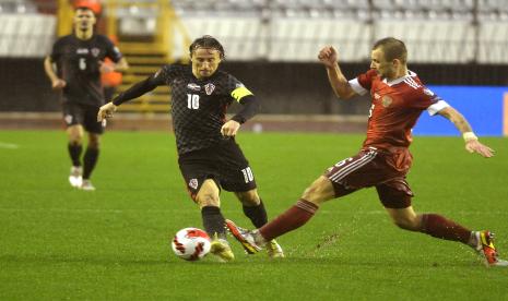 Kapten Kroasia Luka Modric (kiri) berusaha menghindari adangan pemain Rusia, Dmitri Barinov pada laga terakhir Grup H Piala Dunia 2022 di Split, Kroasia, Senin (15/11) dini hari WIB.