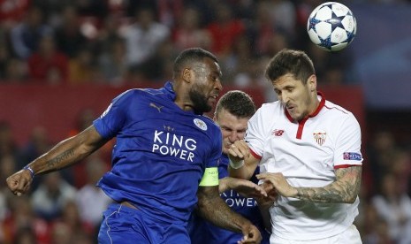 Kapten Leicester City, Wes Morgan (kiri) berebut bola di udara.