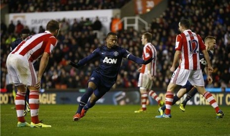 Kapten Manchester United, Patrice Evra (tengah), melakukan selebrasi usai menjebol gawang Stoke City dalam laga Piala Liga di Stadion Britannia pada Rabu (18/12). 