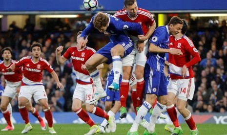 Kapten Middlesbrough Ben Gibson (tengah merah) berduel bola udara dengan gelandang Chelsea Marcos Alonso.