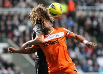 Kapten Newcastle United, Fabricio Coloccini (kiri), terlibat duel udara dengan kapten Swansea City, Ashley Williams, di laga Liga Primer di Sports Direct Arena, Newcastle, Sabtu (17/12). 