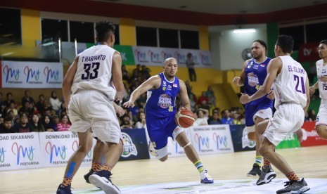 Kapten Satria Muda Pertamina Arki Dikania Wisnu membawa bola saat menghadapi NSH Jakarta pada laga  ketiga semifinal IBL Pertamax 2018/2019.