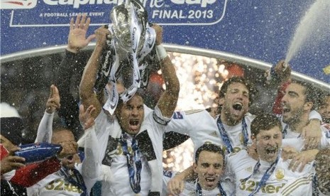 Kapten Swansea City, Ashley Williams (dua kiri), memegang trofi bersama rekan setimnya usai mengalahkan Bradford City 5-0 di final Piala Liga di Stadion Wembley, London, Ahad (24/2). 