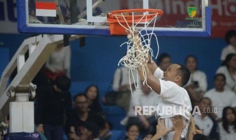 Kapten tim Satria Muda Pertamina Arki Dikania Wisnu menggunting jaring ring Gelanggang Mahasiswa Soemantri Brodjonegoro, Kuningan, Jakarta.  