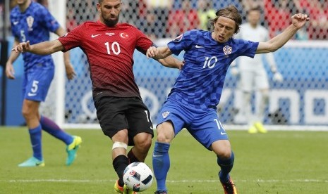  Kapten tim Turki, Arda Turan (kiri) berebut bola dengan pemain Kroasia Luka Modric dalam babak penyisihan grup D Piala Eropa 2016 di Parc des Princes Stadium di Paris, Prancis, Ahad (12/6) waktu setempat. 