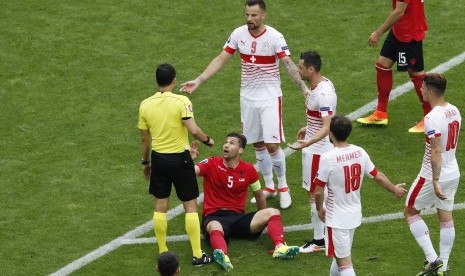 Kapten Timnas Albania, Lorik Cana (dua kiri), coba memprotes keputusan wasit dalam laga lawan Swiss di laga Grup A Piala Eropa 2016 di Stade Bollaert Delelis, Lens, Prancis, Sabtu (11/6). 