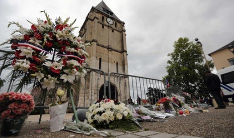 Karangan bunga dari Asosiasi Muslim Prancis diletakkan di samping gereja dimana serangan pisau menewaskan seorang pendeta di Saint-Etienne-du-Rouvray, Normandy, Prancis, Rabu, 27 Juli 2016.