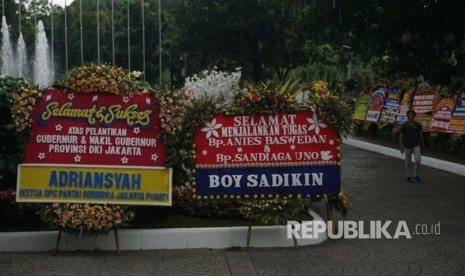 Karangan bunga ucapan selamat kepada Anies Baswedan dan Sandiaga Uno menghiasi halaman Balai Kota DKI Jakarta, Senin (16/10). 