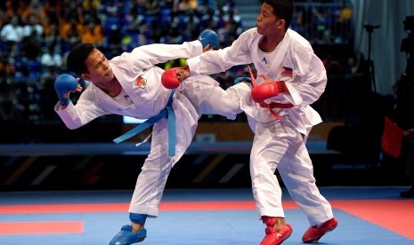 Karateka putra Indonesia Iwan Bidu Sirait (kiri) melepaskan tendangan saat melawan karateka putra Filipina John Paul Bejar dalam perebutan medali emas karate nomor kumite -55 Kg putra SEA Games XXIX Kuala Lumpur di KLCC, Kuala Lumpur, Malaysia, Rabu (23/8). 