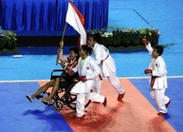 Karateka putri Indonesia, Fitrianingsih Nur Hadiyanti (du kanan), Yulanda Asmuruf (tengah), dan Martinel Prihastuti (kanan) mengarak rekannya Tantri Widyasari yang cedera saat bertanding seusai pertandingan babak final Kumite Beregu Putri SEA Games XXVI me