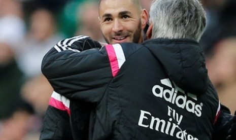 Striker Real Madrid Karim Benzema dipeluk oleh pelatihnya, Carlo Ancelotti (kanan).