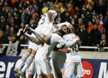  Karim Benzema (dua kanan), striker Real Madrid, merayakan golnya bersama rekan setim saat menghadapi APOEL Nicosia di leg pertama babak perempat final Liga Champions di Stadion GSP, Nicosia, Selasa (27/3).