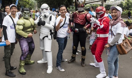 Karyawan bank BJB berfoto dengan tokoh komik saat Family Fun Walk HUT ke-56 bank BJB di Jakarta, Minggu (14/5). 