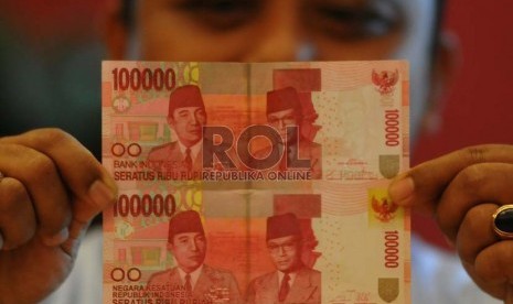 Karyawan Bank Indonesia memerlihatkan uang kertas pecahan Rp. 100.000 baru (atas) dan lama (bawah) usai launching uang tersebut di Bank Indonesia,Jakarta, Senin (18/8). (Republika/Prayogi)