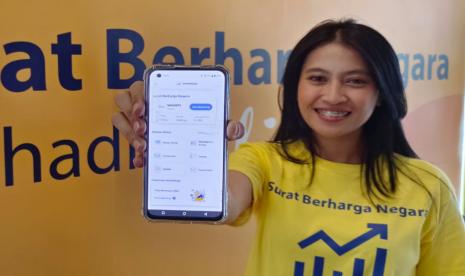 Karyawan Bank Mandiri menunjukkan instrumen investasi Surat Berharga Negara (SBN) Ritel.