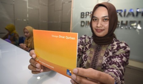 Karyawan Bank Perkreditan Rakyat Syariah (BPRS) Dinar Ashri menunjukkan buku produk tabungan syariah Dinar Qurban di Mataram, NTB, Jumat (15/2). Kompartemen Bank Pembiayaan Rakyat Syariah (BPRS) ASBISINDO menggelar Musyawarah Nasional (Munas) secara offline dan online dengan diikuti anggota yang tersebar di seluruh Provinsi, Kabupaten dan Kotamadya di Indonesia. 