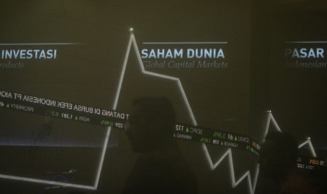 Karyawan beraktivitas di dekat grafik pergerakan saham di gedung Bursa Efek Indonesia, Jakarta, Senin (15/7/2019).