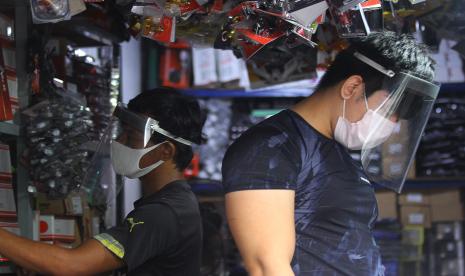 Karyawan beraktivitas menggunakan masker dan alat pelindung wajah (face shield) di salah satu toko di Jalan Kapasan, Surabaya, Jawa Timur.Usaha mikro kecil menengah (UMKM) di Kota Surabaya, Jawa Timur, memproduksi ribuan masker dan alat pelindung diri (APD) tenaga medis setiap hari.