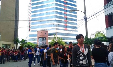 Karyawan keluar dari gedung setelah gempa mengguncang Davao, Filipina, Selasa (29/10). Gempa besar terasa di kawasan Filipina selata Selasa pagi.