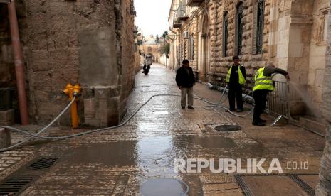 Karyawan Kotamadya Yerusalem membersihkan lorong di sebelah Gerbang Lions yang mengarah ke kompleks Masjid Al-Aqsa di Kota Tua Yerusalem, Senin (23/3). Otoritas Muslim (Waqf) mengumumkan bahwa kompleks Masjid Al-Aqsa, atau kuil di gunung , akan ditutup untuk para jamaah dan masyarakat mulai dari 23 Maret sebagai tanggapan atas 