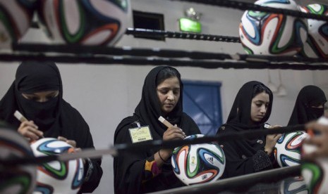 Karyawan melakukan pemeriksaan akhir untuk memperbaiki rongga lapisan bola di pabrik bola sepakbola yang memproduksi bola Piala Dunia 2014 Brasil di Sialkot, Provinsi Punjab, Pakistan, 16 Mei 2014. 