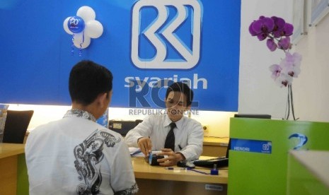 Karyawan melayani nasabah di Bank BRI Syariah, Jakarta, Kamis (17/12).