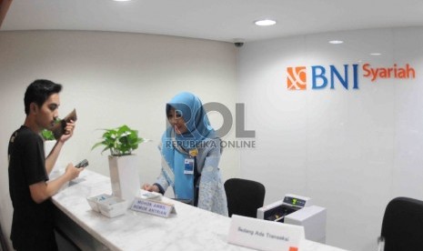 Karyawan melayani nasabah di banking hall Bank BNI Syariah, Jakarta, beberapa waktu lalu..