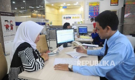 Karyawan melayani nasabah di Banking Hall Bank BTN Syariah, Jakarta, Kamis (12/1).