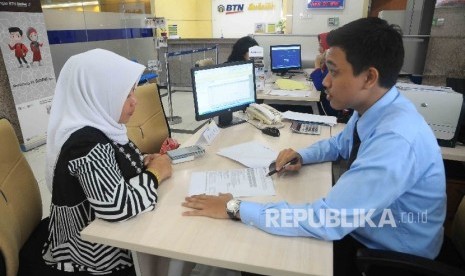 Karyawan melayani nasabah di Banking Hall Bank BTN Syariah, Jakarta, Kamis (12/1).