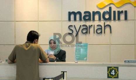 Karyawan melayani nasabah di Banking Hall Gedung Bank Syariah Mandiri (BSM), Jakarta, Rabu (30/9).