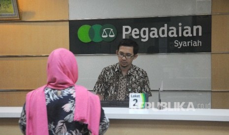 Karyawan melayani nasabah di kantor pelayanan Pegadaian Syariah, Jakarta, Jumat (24/3).