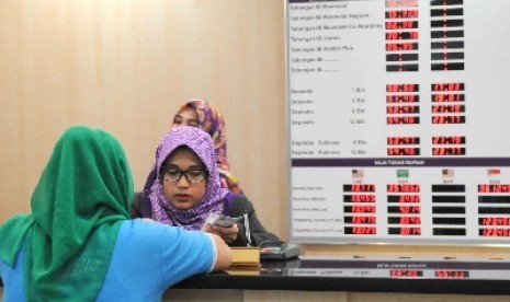 Karyawan melayani nasabah disalah satu Bank Syariah di Jakarta, Jumat (6/11).