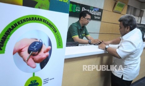 Karyawan melayani nasabah saat bertransaksi di Pegadaian Syariah, Jakarta, Selasa (20/6). 