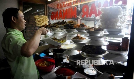  Karyawan melayani pembeli nasi padang di Kawasan Jalan Sabang, Jakarta, Ahad (8/1).