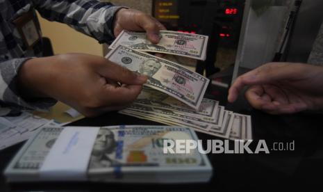 Karyawan melayani pembelian uang dolar Amerika Serikat (AS) di sebuah tempat penukaran uang di Jakarta, Jumat (20/11). Nilai tukar (kurs) rupiah terhadap dolar AS yang ditransaksikan antarbank di Jakarta pada Kamis (26/8) pagi, bergerak melemah ke posisi Rp 14.410 per dolar AS.