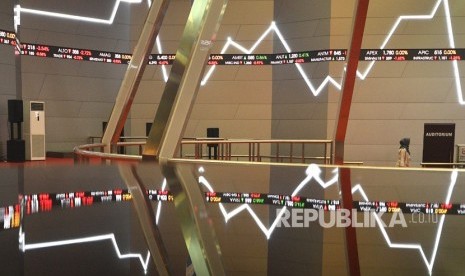 Karyawan melintas di antara monitor pergerakan Indeks Harga Saham Gabungan (IHSG) di Bursa Efek Indonesia, Jakarta.