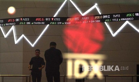 Karyawan melintas di bawah monitor pergerakan Indeks Harga Saham Gabungan (IHSG) Bursa Efek Indonesia, Jakarta, Selasa (19/12). IHSG kembali mencetak rekor tertinggi baru sepanjang masa dengan ditutup naik 33,70 poin atau 0,55 persen sehingga menjadi 6.167,67 setelah sebelumnya juga sempat rekor di level 6.113,653 pada Kamis 14 Desember 2017. 