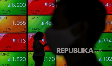 Karyawan melintas di dekat layar monitor pergerakan Indeks Harga Saham Gabungan (IHSG) di Bursa Efek Indonesia, Jakarta, Selasa (29/6/2021). IHSG ditutup di zona hijau dengan penguatan 0,16 persen ke level 5.949,05. 