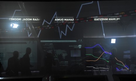 IHSG Melemah: Karyawan melintas di dekat layar pergerakan saham di Bursa Efek Indonesia, Jakarta, Jumat (22/2/2019).