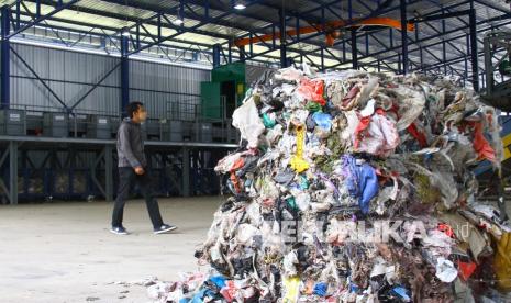 Karyawan melintas di depan gudang penyortiran sampah di proyek prioritas pengembangan Tempat Pembuangan Akhir (TPA) yang tuntas dibangun di Supit Urang, Malang, Jawa Timur, Jumat (10/9/2021). Proyek yang merupakan kerja sama antara Pemerintah Indonesia melalui Ditjen Cipta Karya Kementerian PUPR dengan Pemerintah Jerman dalam Program Emission Reduction in Cities (ERiC) in Malang Municipality senilai Rp230 Milliar tersebut diharapkan mampu menghasilkan produk berbahan sampah seperti pelet, kompos dan gas metan. 