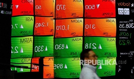 Karyawan melintas di depan layar pergerakan Indeks Harga Saham Gabungan (IHSG), Bursa Efek Indonesia, Jakarta, Senin (10/6/2019).